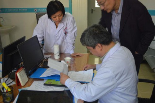 　　亚洲（北京）国际肝病研究院专家委员会的专家委员查看老人的病例